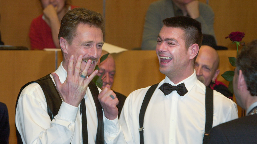 Due sposi dello stesso sesso sorridono durante una cerimonia di matrimonio nei Paesi Bassi nel 2001